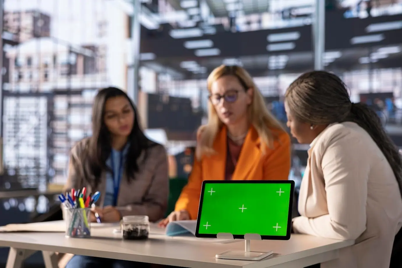 Разнообразная группа бизнесвумен разрабатывает стратегию в профессиональном офисе на фоне зеленого экрана.